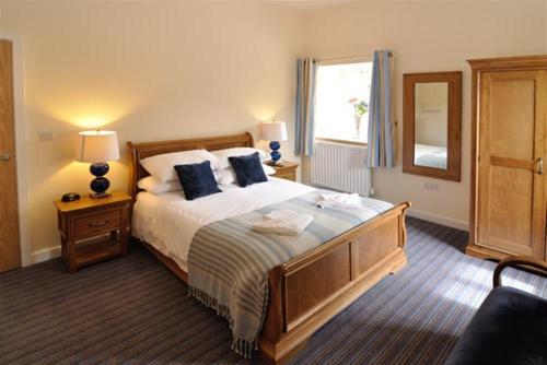 a bedroom with a large bed with blue pillows at Y Felin in Cardigan