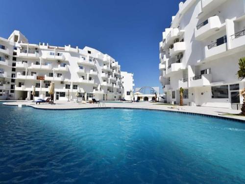 uma piscina em frente a dois edifícios de apartamentos em Apartment Bella Rosa near the sea RedSeaLine em Hurghada