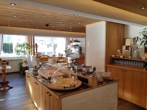 a restaurant with a counter with food on it at Hotel Europa Guest House in Saas-Fee