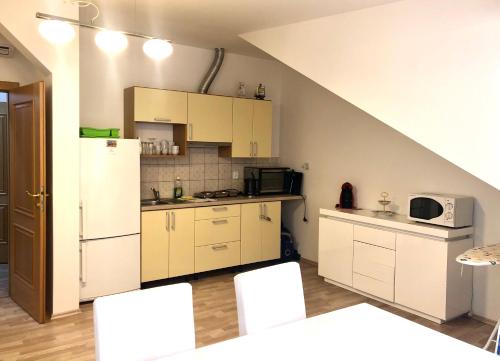 a kitchen with white cabinets and a white refrigerator at Apartments Valencia in Karlovy Vary