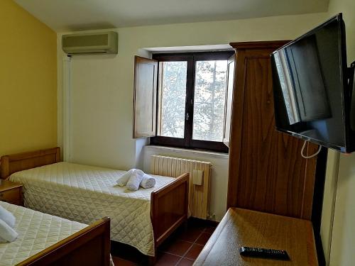 阿西西Casa per Ferie Ulivo d'Assisi的一间有两张床和一台平板电视的房间