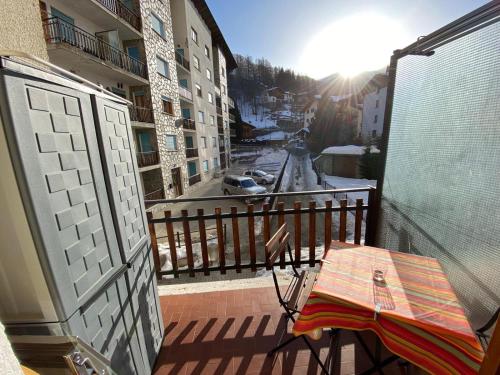 a balcony with a table and an umbrella on a balcony at Il piccolo rifugio - Casa Valtournenche in Valtournenche