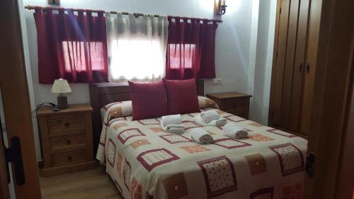 um quarto com uma cama grande e cortinas vermelhas em La Reserva em Pajaroncillo
