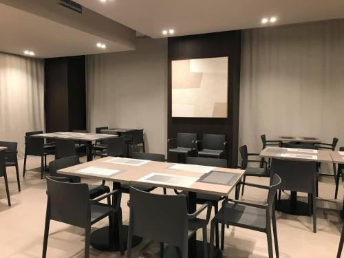 a dining room with tables and chairs and a painting at Hotel Santin in Pordenone