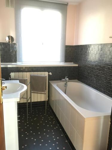 a bathroom with a tub and a sink at Calme et lumière à proximité de la Vieille Ville de Boulogne sur mer in Boulogne-sur-Mer