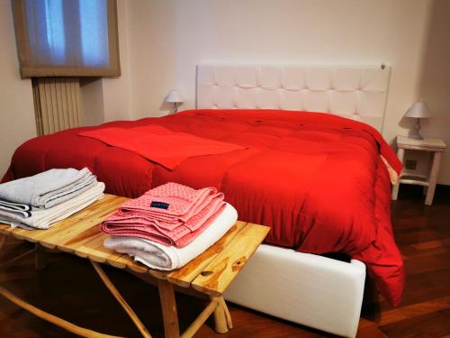a bedroom with a red bed and a table with towels at La Sibilla in Macerata