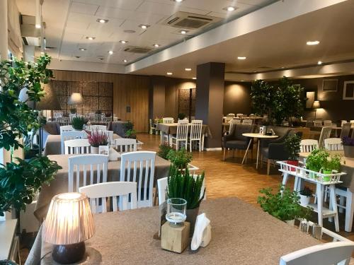 jadalnia z białymi krzesłami, stołami i blatem w obiekcie Hotel Arkadia Jelcz-Laskowice w mieście Jelcz