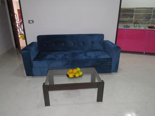 a blue couch and a table with fruit on it at Apartment Sorrento near the sea RedSeaLine in Hurghada