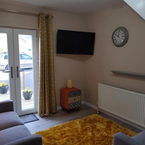 a living room with a flat screen tv on the wall at Chynoweth Court in Newquay