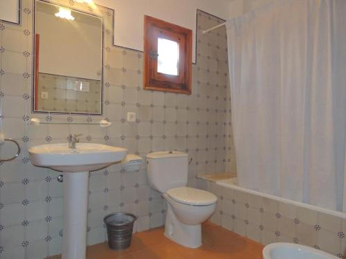 a bathroom with a white toilet and a sink at Apartamentos Rocas Marinas in Punta Grossa