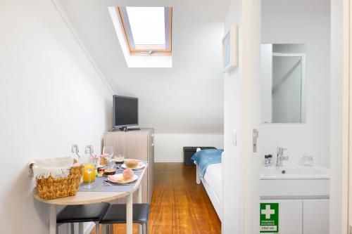 Camera piccola con tavolo e lavandino di Porta 34 Apartments a Braga