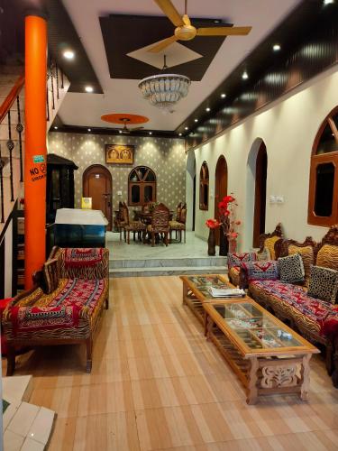 a living room with couches and a coffee table at Hotel Rashmi in Agra