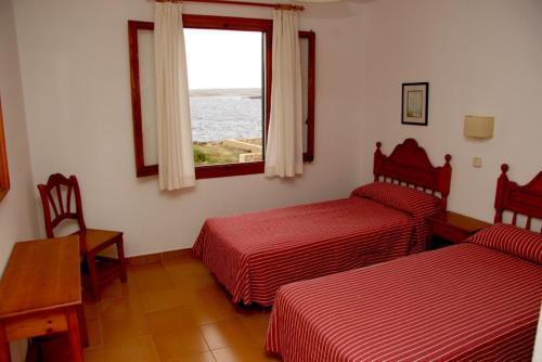 Habitación de hotel con 2 camas y ventana en Apartamentos Rocas Marinas, en Punta Grossa