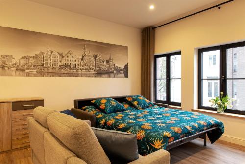 a living room with a bed and a couch at B&B Steendam 66 in Ghent