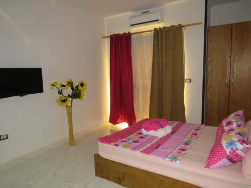 um quarto com uma cama com lençóis cor-de-rosa e uma janela em Apartment Bella Rosa near the sea RedSeaLine em Hurghada