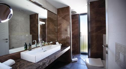 a bathroom with a tub and a sink and a toilet at Elke Spa Hotel in Sant Feliu de Guíxols