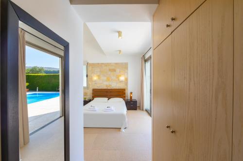 ein Schlafzimmer mit einem Bett und einem Pool in der Unterkunft Villa Zoe in Miliou