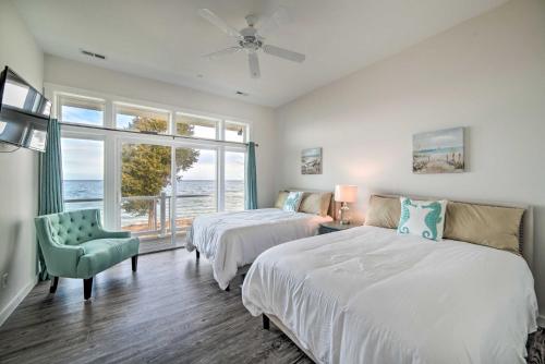 1 dormitorio con 2 camas, silla y ventana en Waterfront Scotland Beach Retreat with Private Beach!, en Ridge