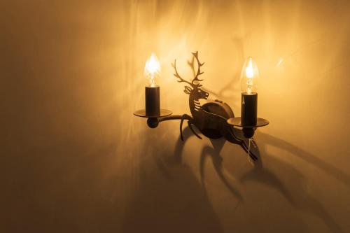 a candle holder with two candles on a wall at Das Kitz - deLuxe ChaletApartments in Jochberg