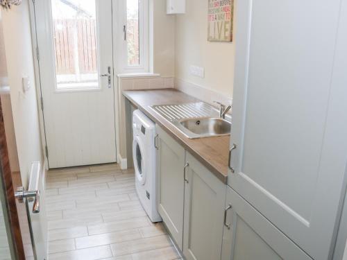 a kitchen with a sink and a washing machine at River Dale in Willsborough