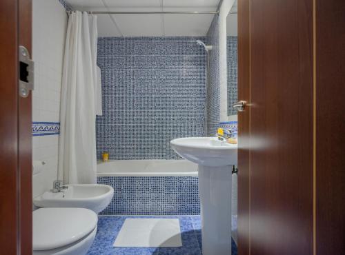 y baño con lavabo, aseo y bañera. en Apartamentos Suites Oficentro, en Málaga