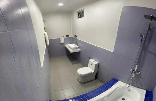 La salle de bains est pourvue de toilettes et d'un lavabo. dans l'établissement Dhonveli Inn, Bandidhoo, à Meedhoo