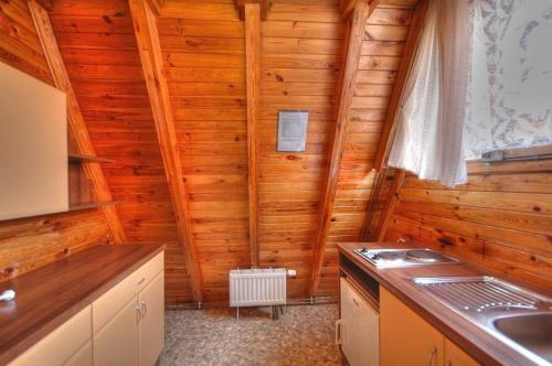 uma cozinha com paredes de madeira e um fogão em Pod Starym Groniem em Brenna