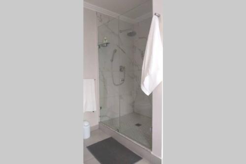 een badkamer met een douche en een glazen deur bij 1B Sugar Crest , Umdloti Beach in Umdloti