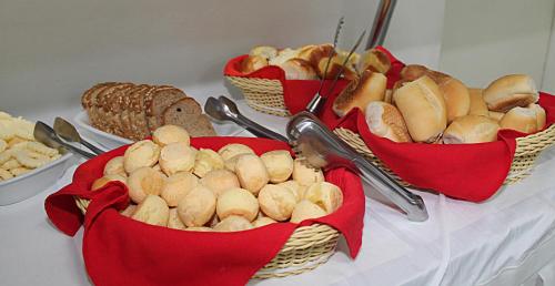 tres cestas de pan y pastas en una mesa en Hotel Pampulha Palace, en Belo Horizonte