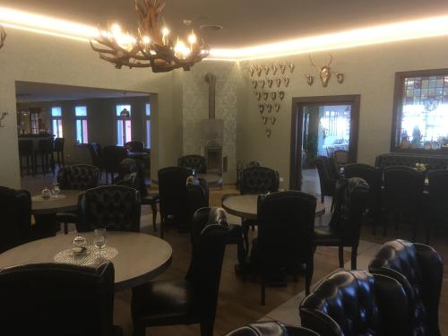 uma sala de jantar com mesas e cadeiras e um lustre em Akzent Berghotel Rosstrappe em Thale