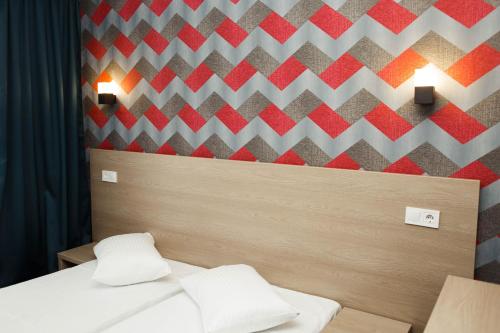 a bedroom with two beds and a geometric wall at River Park hotel in Kovelʼ