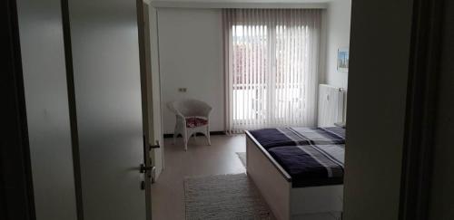 Schlafzimmer mit einem Bett und einem Fenster mit einem Stuhl in der Unterkunft Ambiente Ferienapartments Warmbad Villach in Villach