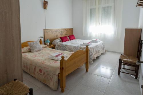 1 dormitorio con 2 camas y ventana en Casa rural LAS TABLAS, en Riópar