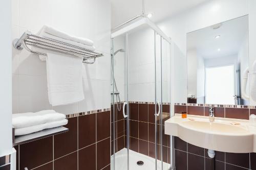 La salle de bains est pourvue d'un lavabo et d'une douche. dans l'établissement Esatitude Hotel, à Nice