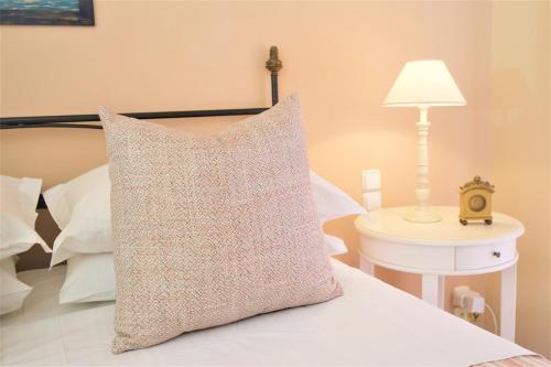 a pillow sitting on top of a bed with a lamp at Agnantia Bed & Breakfast in Fiskardho
