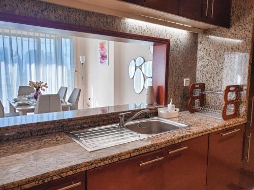 a kitchen with a sink and a large mirror at Stay Here - Downtown South Ridge 2BR apartment in Dubai