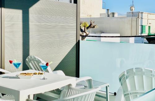 a white table and chairs on a balcony at Canaryislandshost l Brisa del Atlántico in Playa Honda