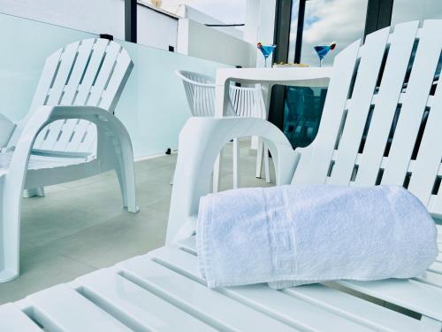 two white chairs sitting next to each other in a room at Canaryislandshost l Brisa del Atlántico in Playa Honda