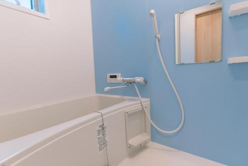 大阪的住宿－暁 Twilight Osaka Inn，带淋浴的浴室,拥有蓝色的墙壁