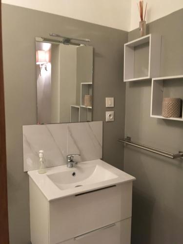 une salle de bain avec un lavabo blanc et un miroir dans l'établissement Les 2 grives - auberge restaurant, à Bras-dʼAsse