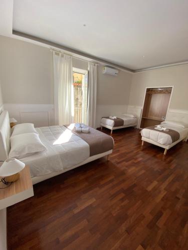 a bedroom with two beds and a large window at MAMO al Museo in Naples