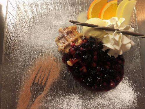 a plate with a dessert with fruit and a fork at Hotel Châlet Du Lac in Iseltwald