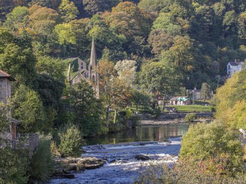 a river flowing through a small town with a church at Plum Hill Studio in Oswestry