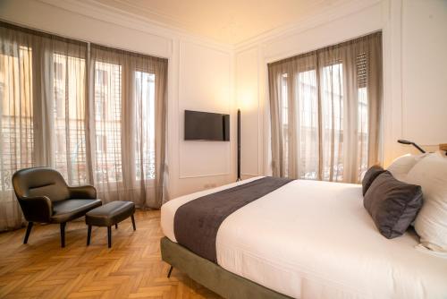 a bedroom with a bed and a chair and a television at Youroom Boncompagni in Rome