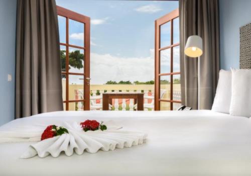 a bedroom with a white bed with flowers on it at Apartamento Familiar Vacaciones en Curacao in Jan Thiel