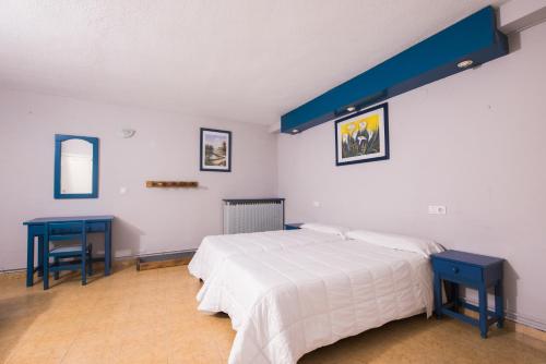 1 dormitorio con 1 cama y 2 mesas azules en El Ciervo, en Sierra Nevada