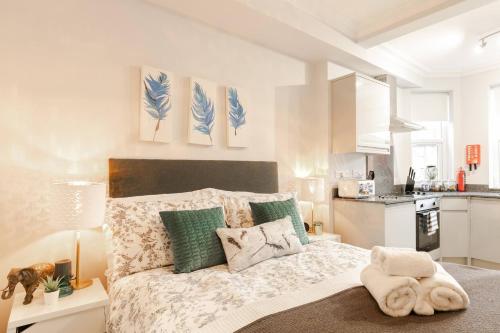 1 dormitorio con 1 cama con almohadas verdes y azules en 12 Helena Luxury Serviced Apartment en Reading