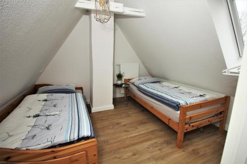 Duas camas num quarto com um sótão em Stadtwohnung zur großen Buche em Leer
