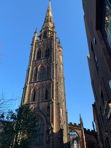 a tall tower with a steeple on top of a building at Belgrade Plaza Serviced Apartments in Coventry