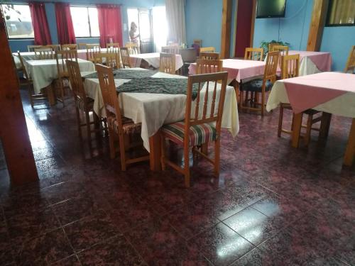 コンスティトゥシオンにあるHostal Casona del Cerroのダイニングルーム(テーブル、椅子、白いテーブルクロス付)
